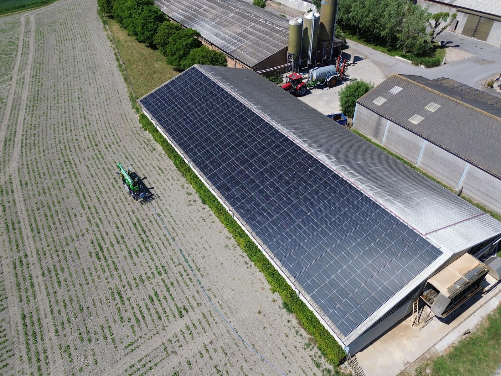 Luchtfoto van een industriële loods met zonnepanelen op het volledige dak